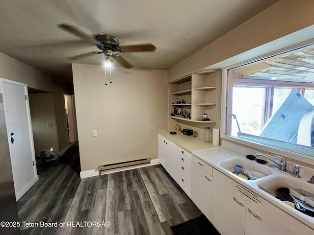 kitchen with a baseboard radiator, dark hardwood / wood-style flooring, a textured ceiling, and white cabinets