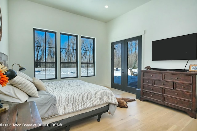 bedroom with access to exterior, french doors, and light wood-type flooring