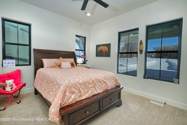 bedroom with multiple windows, light carpet, and ceiling fan