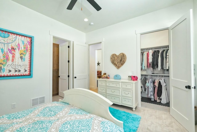 bedroom with a spacious closet, ceiling fan, and a closet