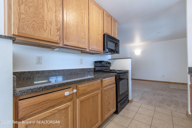 kitchen featuring light colored carpet, dark stone counters, and black appliances