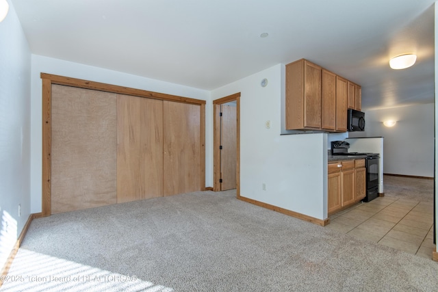 kitchen featuring light carpet and black appliances