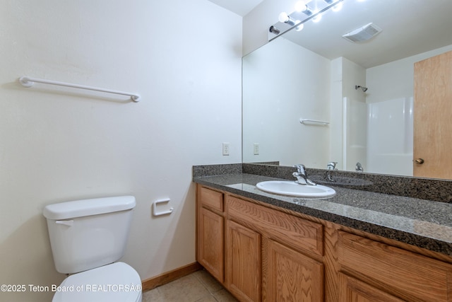 bathroom featuring tile patterned flooring, vanity, a shower, and toilet