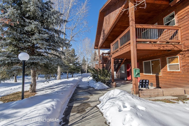 snow covered property featuring a wooden deck