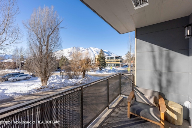 snow covered back of property featuring a mountain view