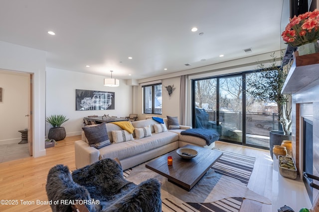 living room with light hardwood / wood-style floors and a premium fireplace