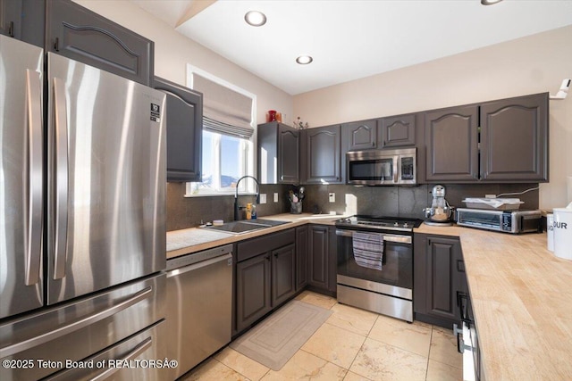 kitchen featuring sink, decorative backsplash, and appliances with stainless steel finishes