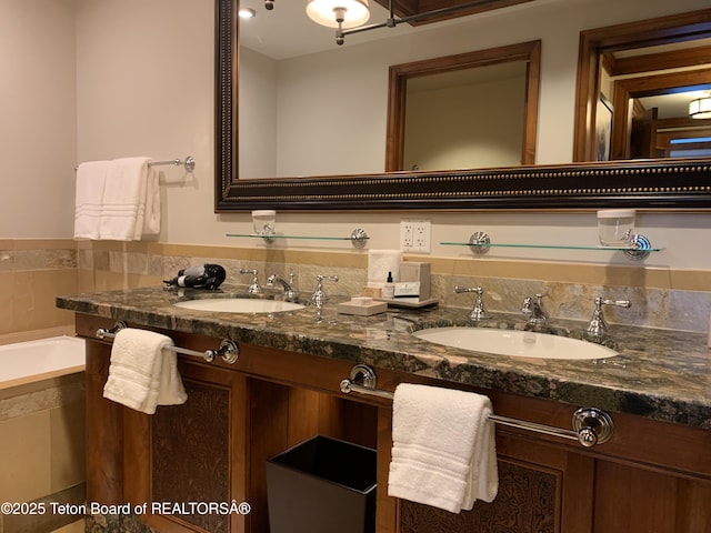 bathroom with vanity and tiled tub