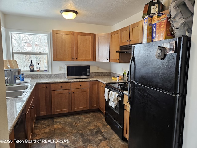 kitchen with sink, light stone counters, a textured ceiling, and black appliances