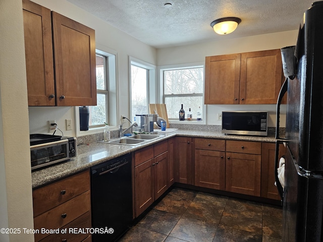 kitchen with sink, plenty of natural light, black appliances, and a textured ceiling