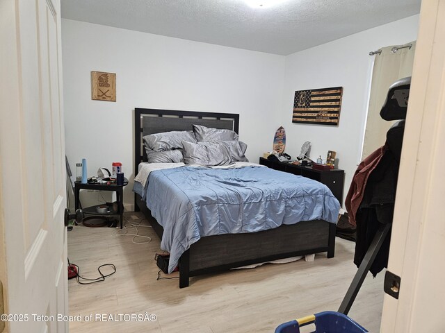 bedroom with hardwood / wood-style flooring and a textured ceiling