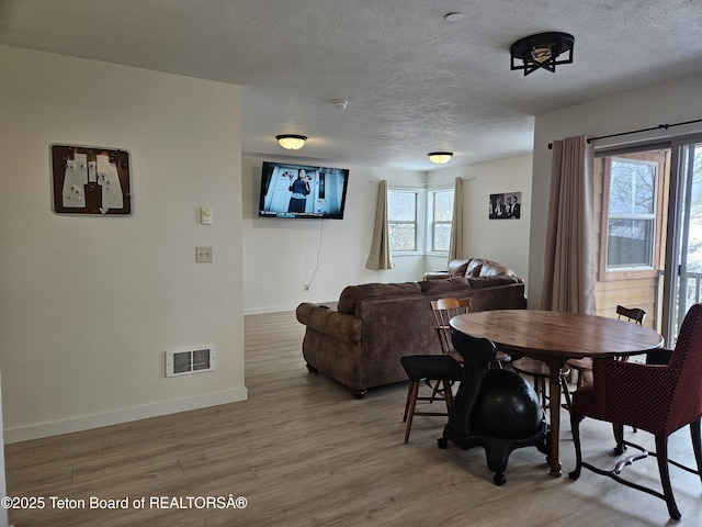 dining room featuring light hardwood / wood-style floors and a textured ceiling