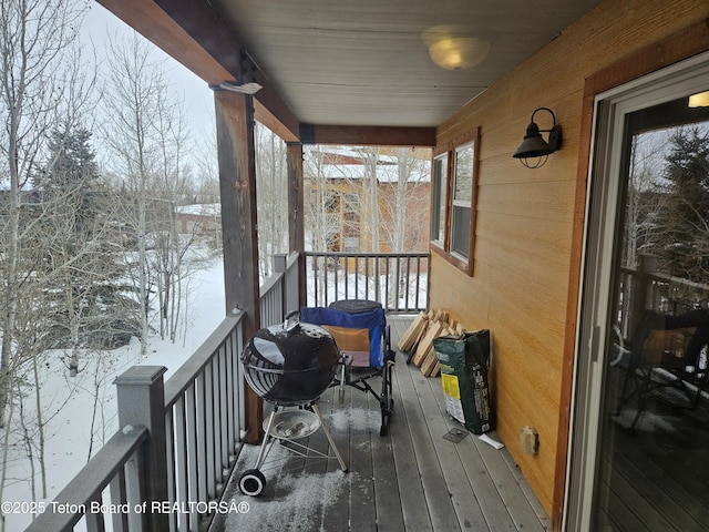 snow covered back of property with a grill