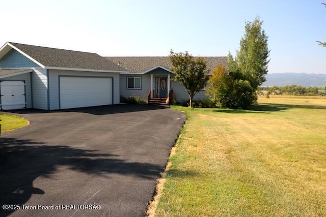 single story home featuring a garage and a front lawn