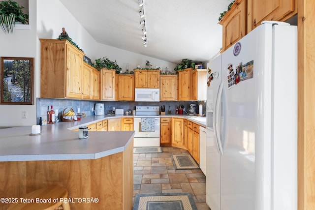 kitchen featuring tasteful backsplash, vaulted ceiling, white appliances, and kitchen peninsula