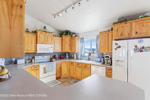 kitchen featuring lofted ceiling, backsplash, white appliances, and sink