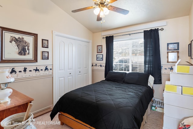 bedroom with vaulted ceiling, light colored carpet, ceiling fan, and a closet