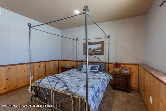 carpeted bedroom with wood walls