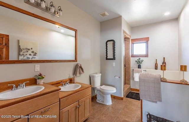 bathroom with vanity, tile patterned floors, toilet, and walk in shower