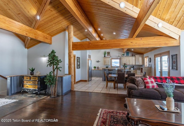 living room featuring beamed ceiling, a healthy amount of sunlight, and light hardwood / wood-style floors