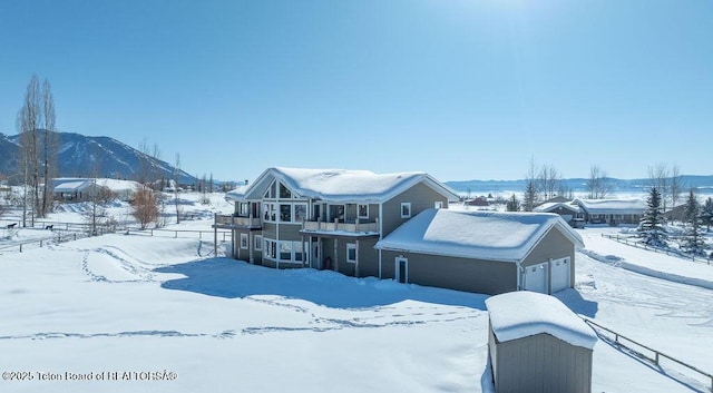 snow covered rear of property with a mountain view