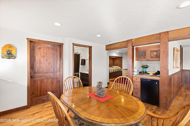 dining space with a textured ceiling and light wood-type flooring