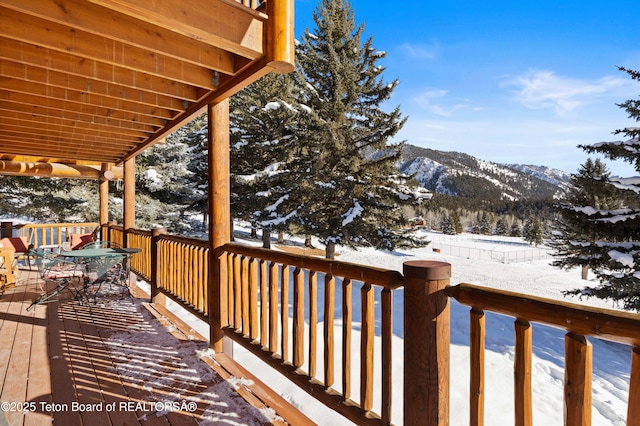 snow covered deck featuring a mountain view