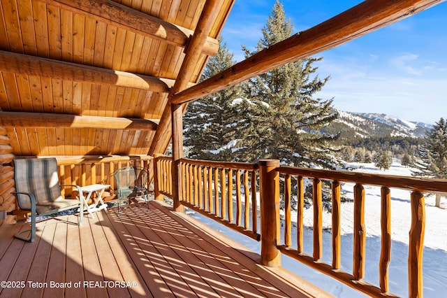 snow covered deck with a mountain view