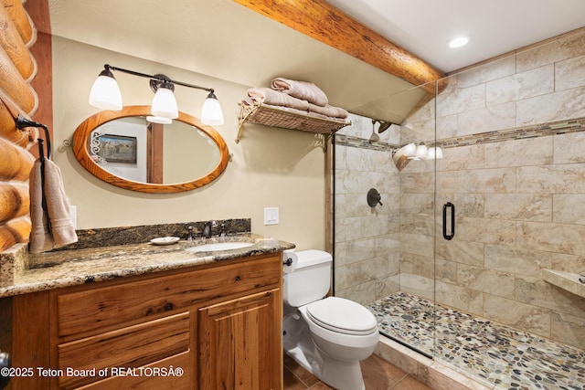 bathroom featuring beamed ceiling, vanity, toilet, a shower with door, and tile patterned floors