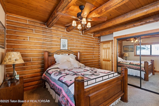 carpeted bedroom featuring beamed ceiling, wooden ceiling, a closet, and rustic walls