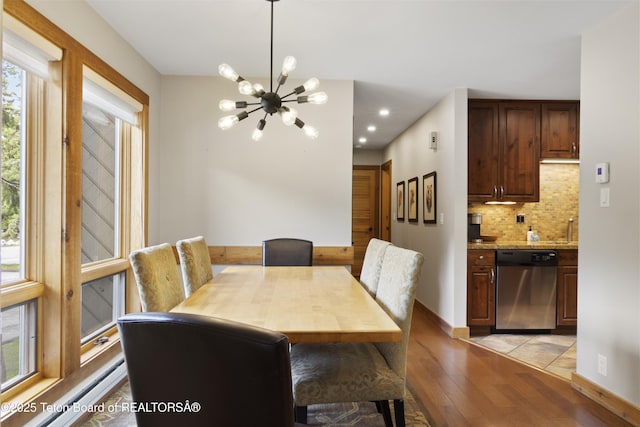 dining room with a notable chandelier, light hardwood / wood-style flooring, and sink