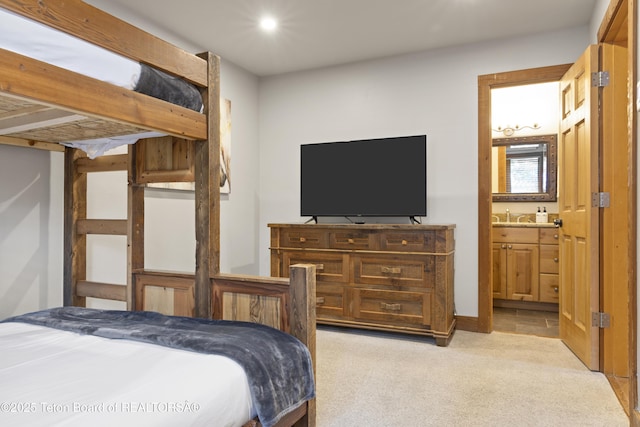 carpeted bedroom with sink and ensuite bath