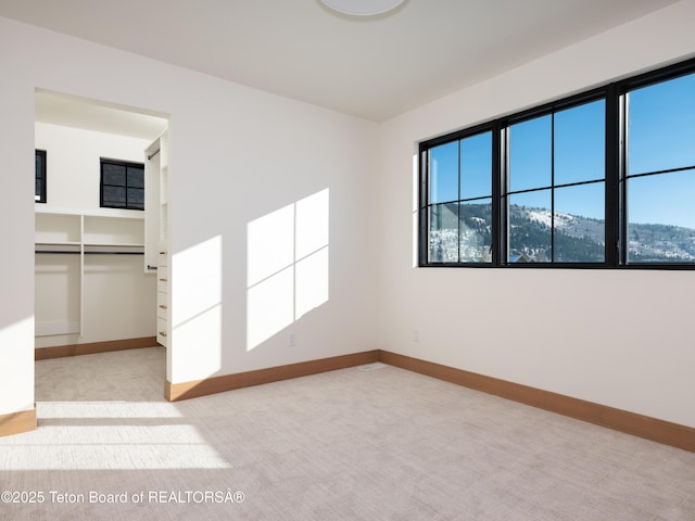 carpeted empty room with a mountain view and a wealth of natural light