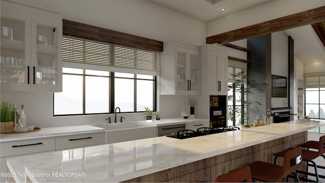 kitchen featuring white cabinetry, sink, light stone counters, and black gas cooktop