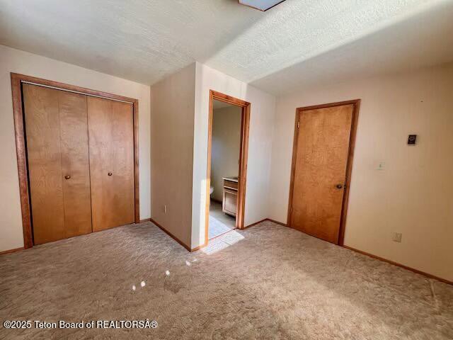 unfurnished bedroom featuring a closet, carpet, and a textured ceiling