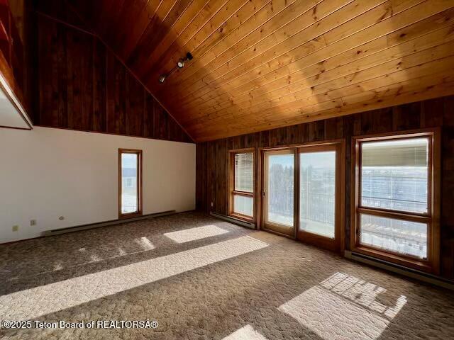 interior space featuring carpet flooring, wooden walls, wooden ceiling, and high vaulted ceiling