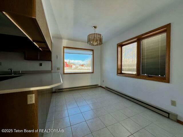 kitchen featuring pendant lighting, plenty of natural light, and baseboard heating