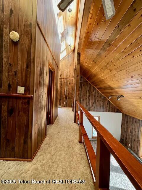 additional living space featuring wooden ceiling, lofted ceiling, light carpet, and wood walls