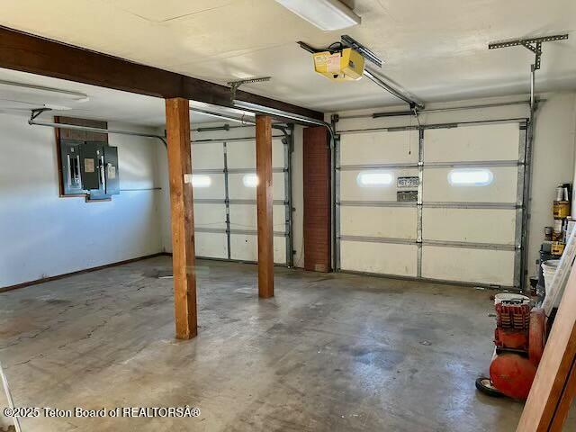 garage with a garage door opener and electric panel