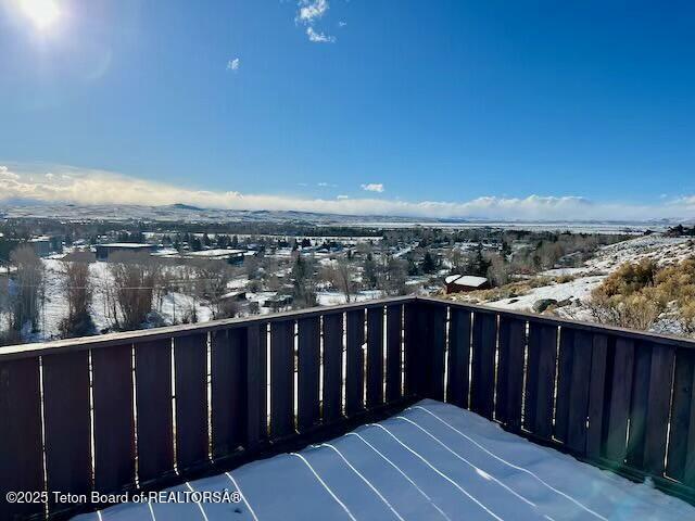 view of snow covered back of property