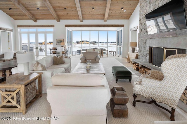 living room with beam ceiling, high vaulted ceiling, a fireplace, wooden ceiling, and french doors