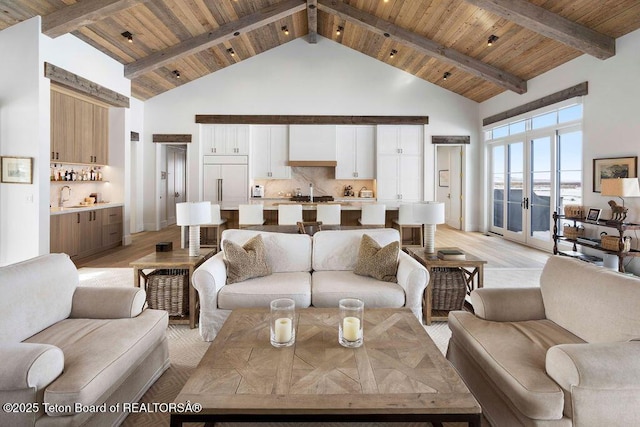 living room featuring beamed ceiling, light hardwood / wood-style floors, high vaulted ceiling, and wooden ceiling