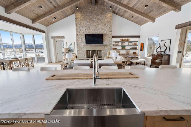 kitchen featuring high vaulted ceiling, sink, and wooden ceiling