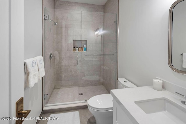 bathroom with vanity, a shower with door, and toilet