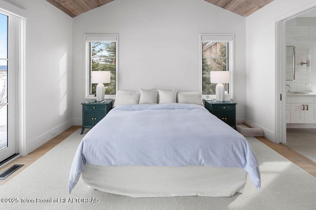 bedroom featuring vaulted ceiling, connected bathroom, wooden ceiling, and light wood-type flooring