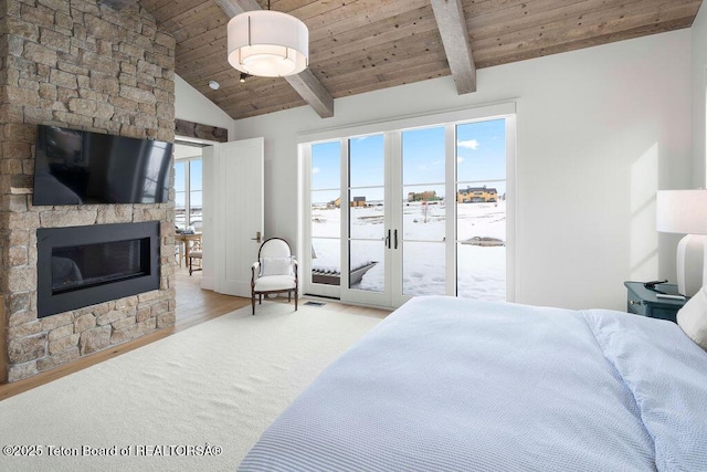 bedroom featuring wood ceiling, lofted ceiling with beams, access to outside, a fireplace, and light hardwood / wood-style floors