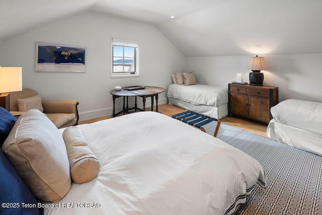 bedroom with lofted ceiling and light wood-type flooring