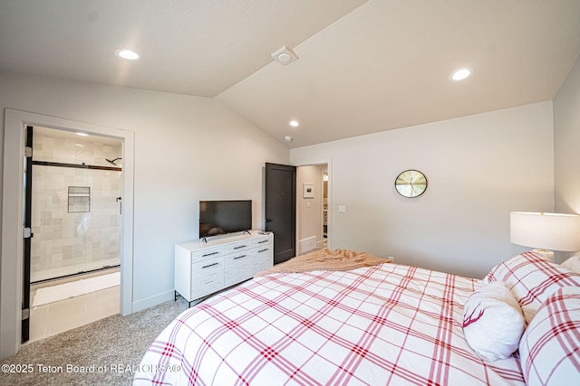 bedroom with connected bathroom, carpet flooring, and vaulted ceiling