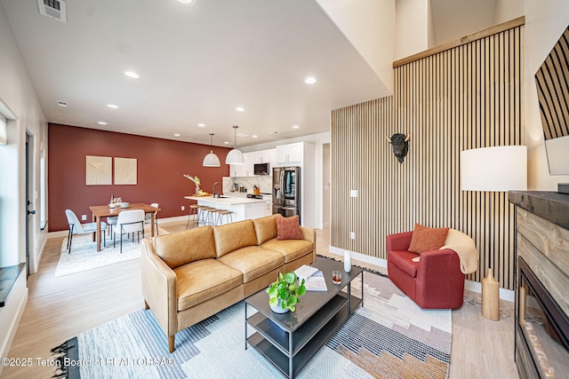 living room with light hardwood / wood-style flooring, sink, and a fireplace