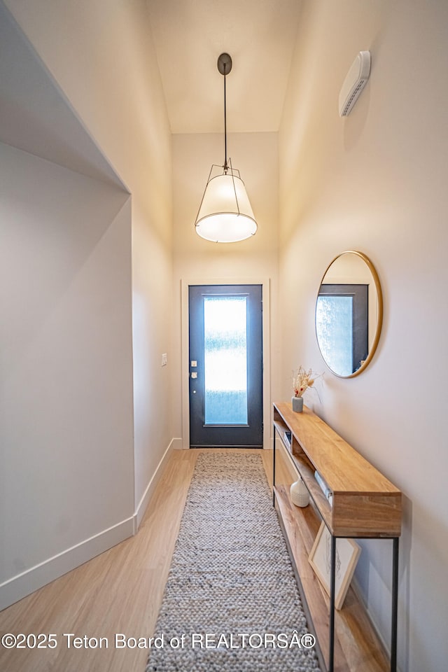 doorway featuring hardwood / wood-style flooring and a towering ceiling